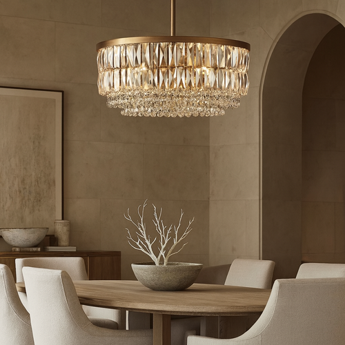A modern dining room features a round wooden table, cream upholstered chairs, and a decorative bowl with branches. The Bacci Crystal Chandelier from Morsale.com hangs above, casting warm light and enhancing the calm, elegant space with neutral tones.