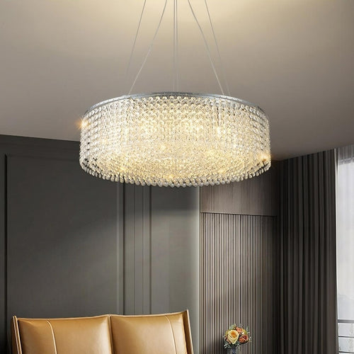 The Alleri Modern Chandelier by Morsale.com hangs from the ceiling in a stylish living room with dark walls, a tan leather sofa, and a vase of flowers on a side table.