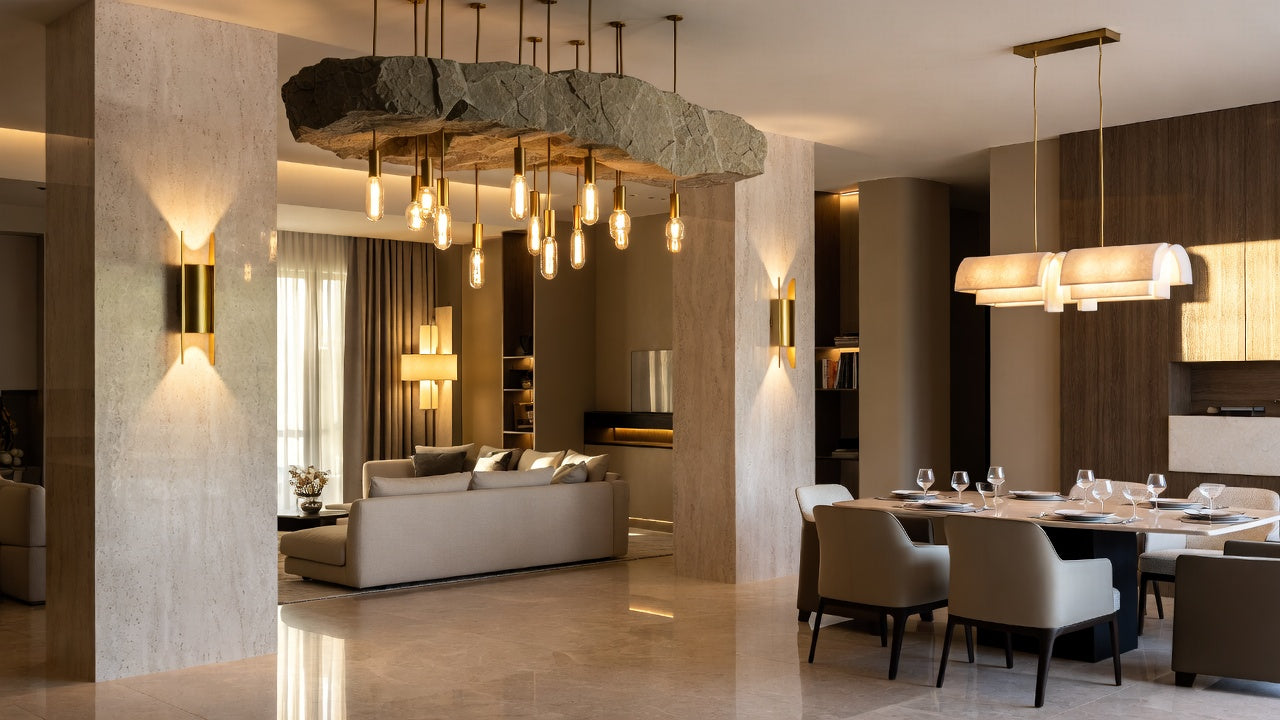 modern interior with gold wall sconces, dining room chandelier over a dining table, and a chandelier in the living room