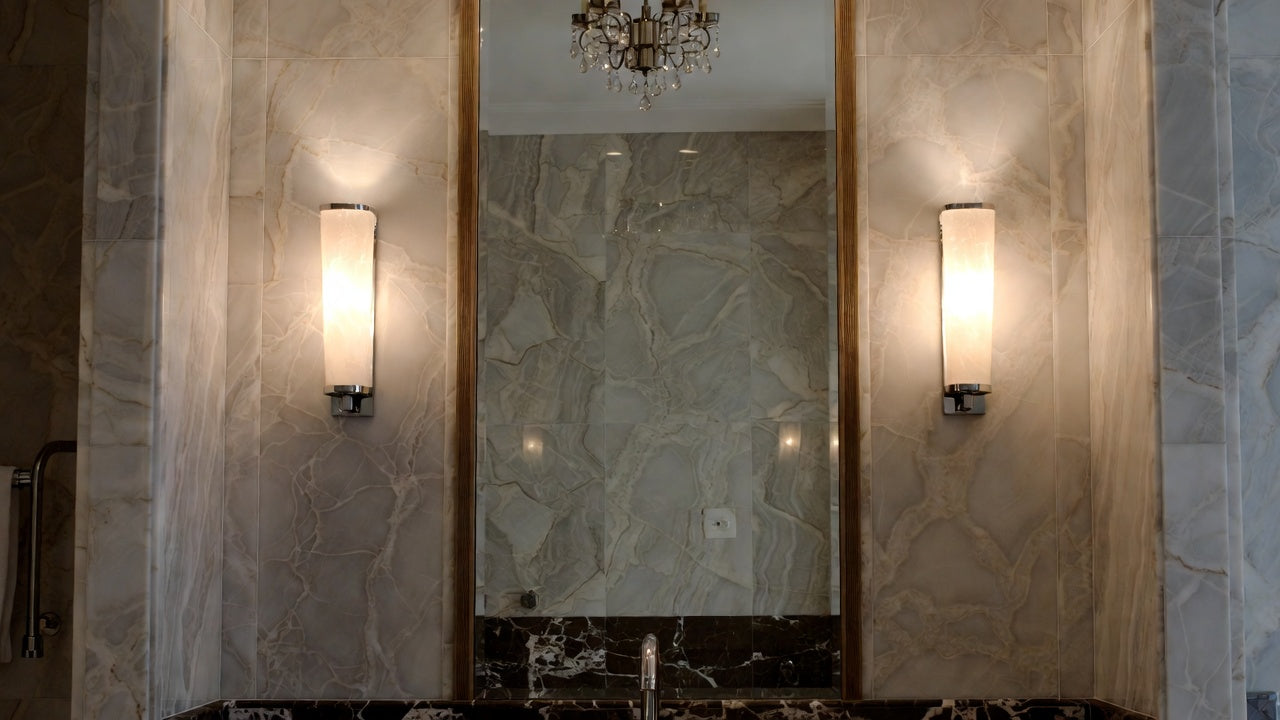 Luxury Bathroom Lighting featuring elegant wall sconces and a stunning chandelier in a marble setting.