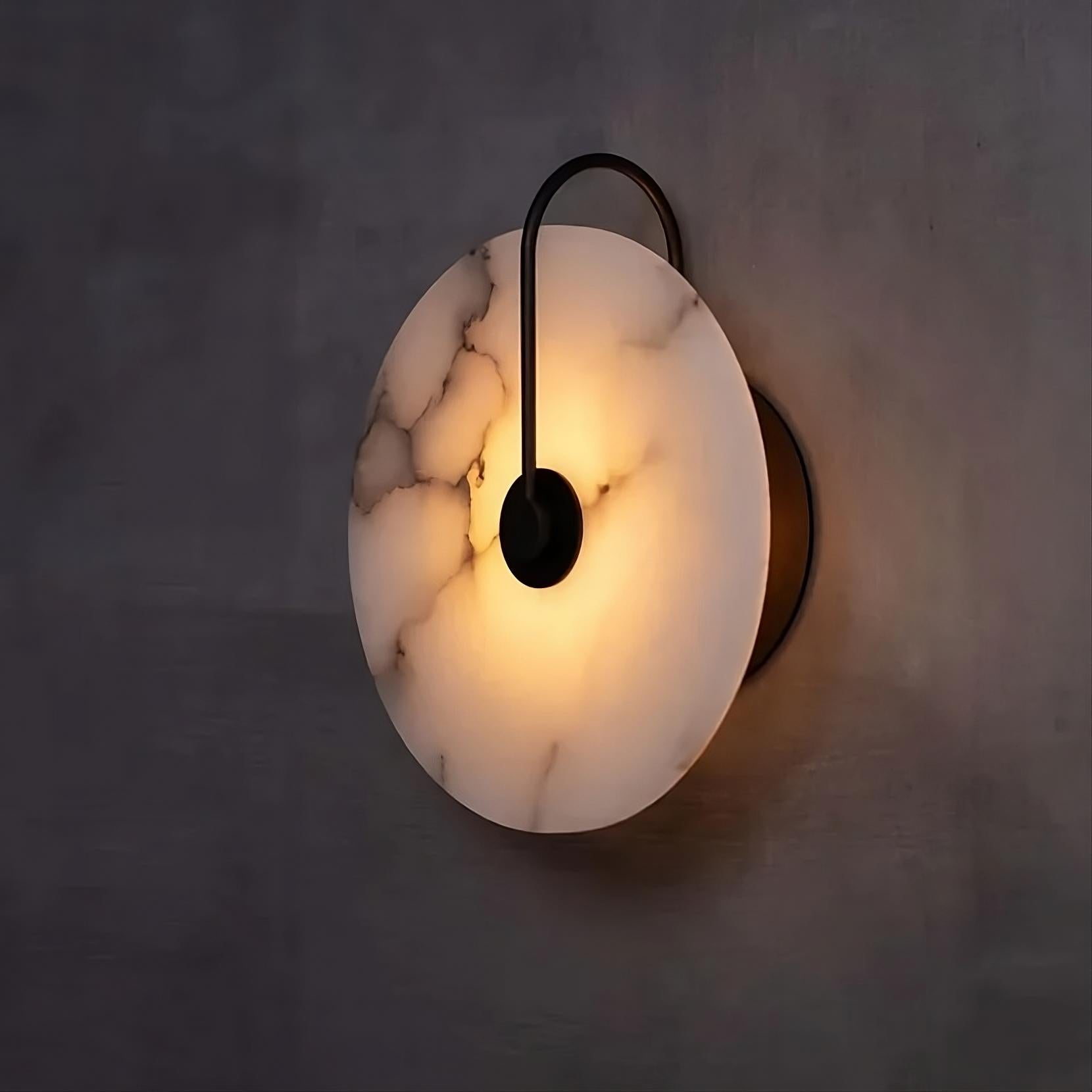 Elegant marble wall sconce with warm illumination on a modern minimalist wall, showcasing luxury and style in contemporary home decor.