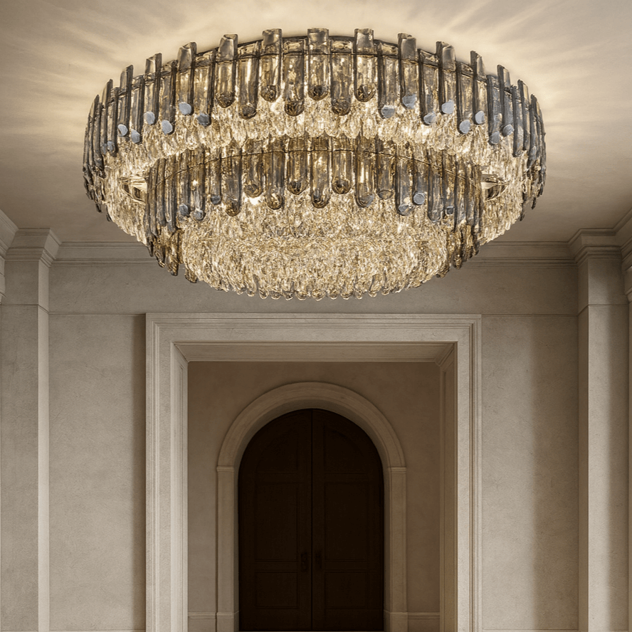 The Venice 2-Tier Crystal Chandelier by Morsale.com, with polished stainless steel accents, hangs in an elegant hallway with arched double doors and light walls, casting a warm, glowing light.