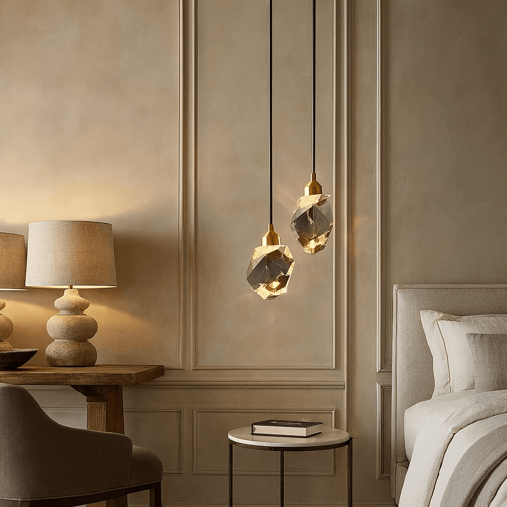 
                  
                    A cozy bedroom corner features a beige bed, the Morsale Valenza Grand Crystal Pendant, a round side table with a sculptural lamp, and a wooden desk against tan paneled walls. Warm modern luxury lighting sets a serene, inviting mood.
                  
                