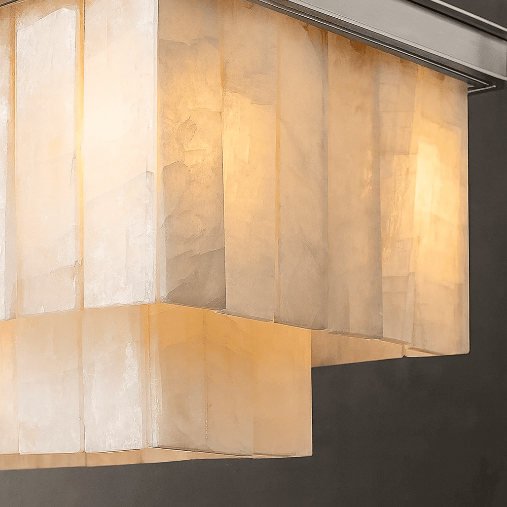 
                  
                    The Windsor Marble Dining Chandelier by Shopp578 features a modern rectangular design with layered translucent panels, softly glowing with warm yellow light against a dark background.
                  
                