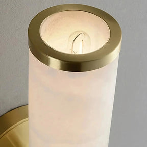 The Moonshade Natural Marble Sconce Light by Morsale.com is a wall-mounted cylindrical light fixture featuring a frosted white glass shade and brass trim on both the top and base. An E14 Base LED bulb is visible inside the shade, casting a soft glow against a neutral wall background.