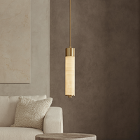 A modern living room with a white textured sofa, plush pillow, round stone side table, and the Sorella Marble PendantLight by Morsale.com illuminating taupe walls and a beige wall art panel.