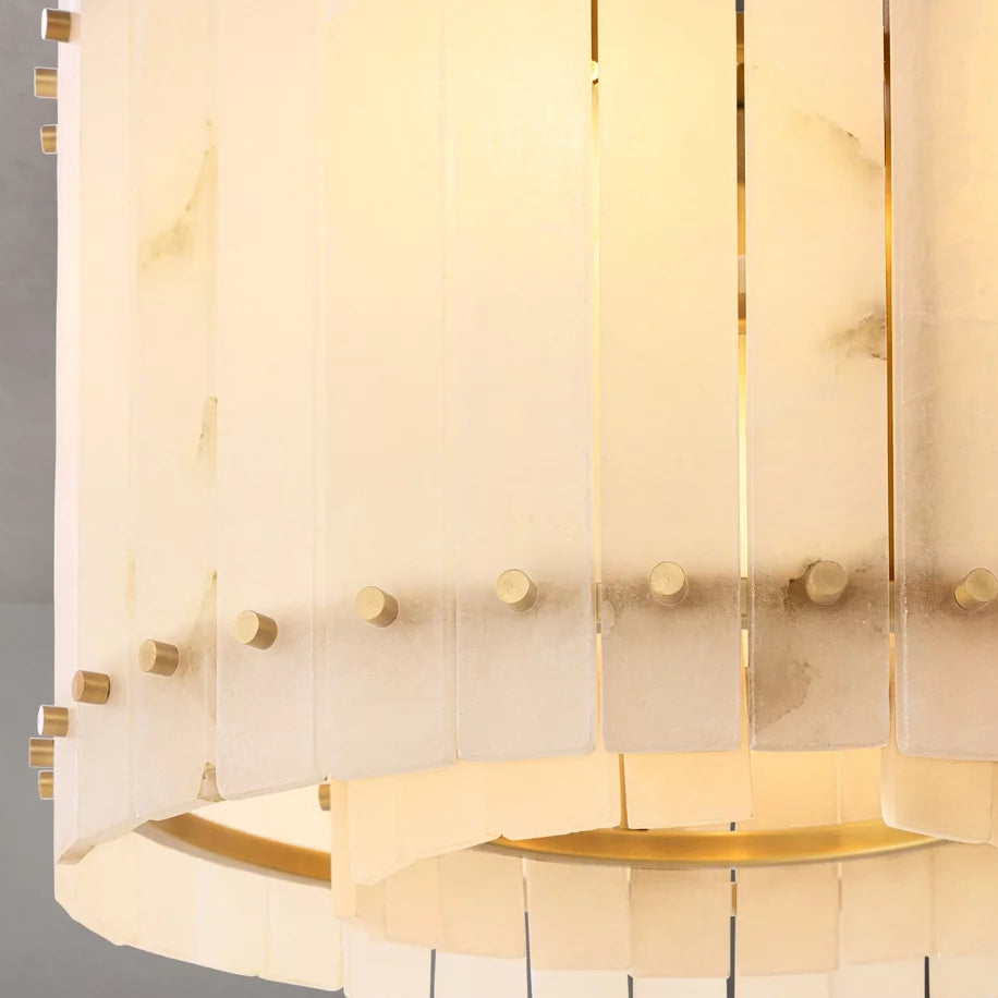 
                  
                    The Valmont Marble Round Chandelier by Morsale features vertical frosted glass panels and gold accents, softly illuminated from within for a warm, elegant glow.
                  
                