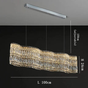 The Bacci Crystal Chandelier For Dining Room by Morsale.com features a modern, rectangular, wave-like design suspended from the ceiling with three wires. Its dimensions include an adjustable height of up to 150cm, a height of 24cm, and a length of 100cm. This luxurious chandelier emits warm light through its multiple crystal facets.