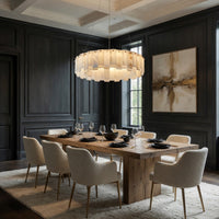 Dining room with wooden table, white chairs, and a large chandelier.