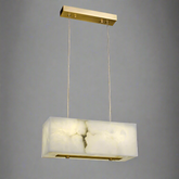 The Natural Marble Dining Room Chandelier by Shopp578 boasts a modern minimalistic design, featuring a translucent alabaster shade. This rectangular pendant light fixture is suspended from a rectangular gold metal plate by two thin wires, offering warm ambient lighting against a plain gray background.