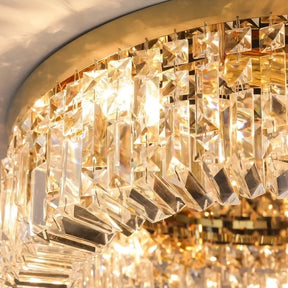 Close-up of the Gio Crystal Ceiling Light by Morsale.com featuring numerous elongated, rectangular prisms hanging from a circular, gold-colored base. The crystals catch and reflect warm LED bulbs, creating a brilliant and intricate display of light and color.