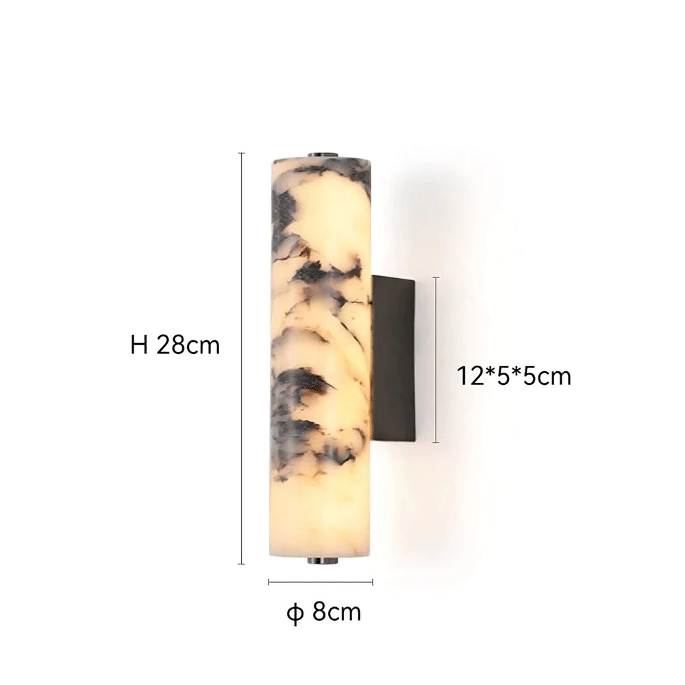 
                  
                    The Morsale Valmont Marble Cylinder Sconce is a modern wall light with a marbled finish, cylindrical shape (28 cm high, 8 cm diameter), and a 12x5x5 cm rectangular base. It emits a warm glow.
                  
                
