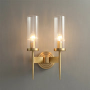The Morsale Palermo Wall Sconce showcases modern elegance, featuring two cylindrical glass shades on a brass fixture. Its LED bulbs cast a soft glow on neutral walls, complemented by sleek, tapered design elements for a contemporary appearance.