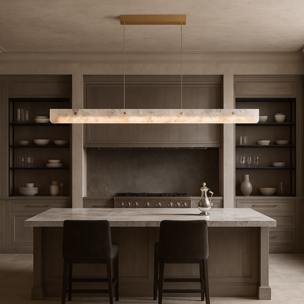 A minimalist kitchen features taupe cabinets, open shelves with white dishes, a marble island with two dark chairs, and the Morsale Eterna Natural Marble Linear Chandelier above. A silver teapot rests on the island.