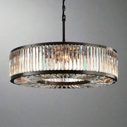 A luxurious round modern chandelier, the Gio Crystal Modern Chandelier by Morsale.com, with a black frame and multiple vertical handmade crystal prisms emits a warm glow against a dark background. The intricate design reflects light, creating a sophisticated ambiance.