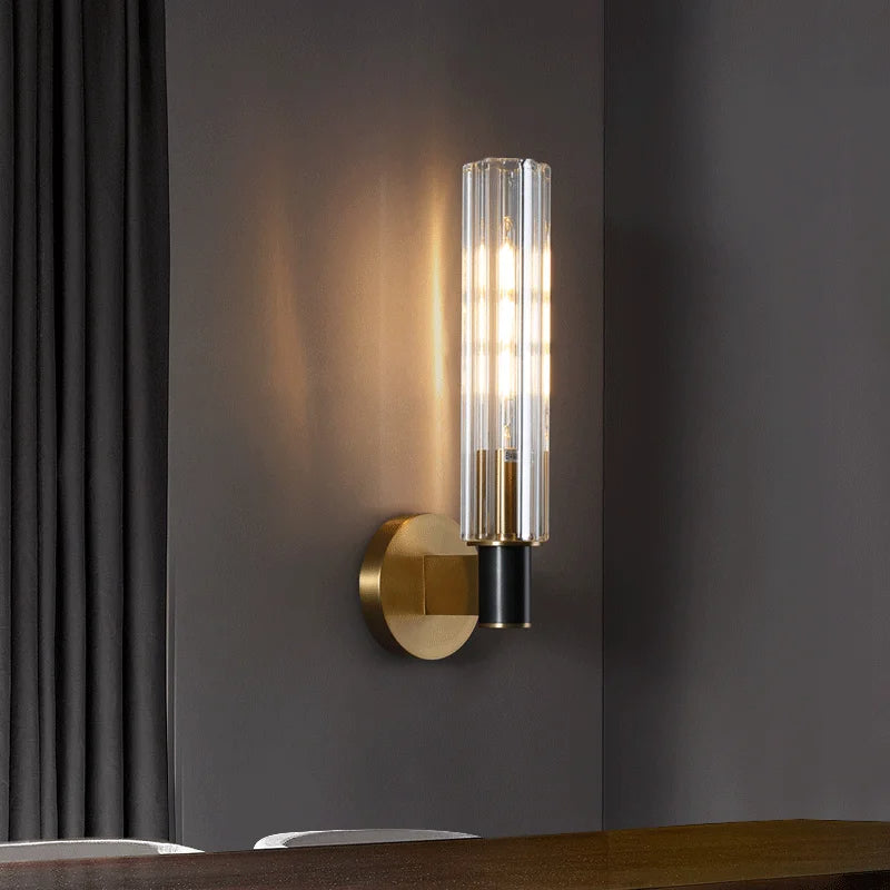 The Morsale Palermo Retro Brass Wall Sconce, featuring a textured glass globe and a brass finish circular wall mount, illuminates elegantly against a dark gray wall.