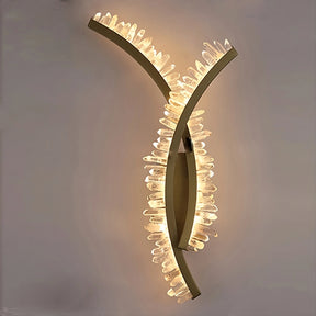 Discover the Morsale Orion Crystal Wall Sconce, showcasing modern design with intersecting curved bars and glowing crystal-like elements. It emits ambient light, casting warmth against any plain backdrop for an elegant ambiance in any room.