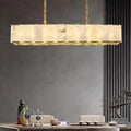 Solaro Marble Chandelier illuminating a modern dining table, natural marble panels with brass frame