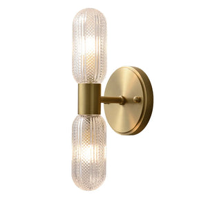 A modern brass wall sconce with a cylindrical design is shown. The Palermo 12" Brass Wall Light Sconce by Morsale features two textured glass bulbs positioned vertically, one above and one below a central fixture that extends from a circular mounting plate, providing warm lighting and an elegant contemporary design.