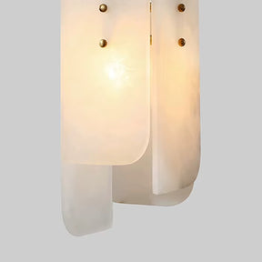 A modern pendant light featuring overlapping frosted glass panels and small brass fixtures that exude a warm glow against a gray background evokes the elegance of the Morsale Moonshade Natural Marble Pendant Lights, adding an exquisite touch to any space.