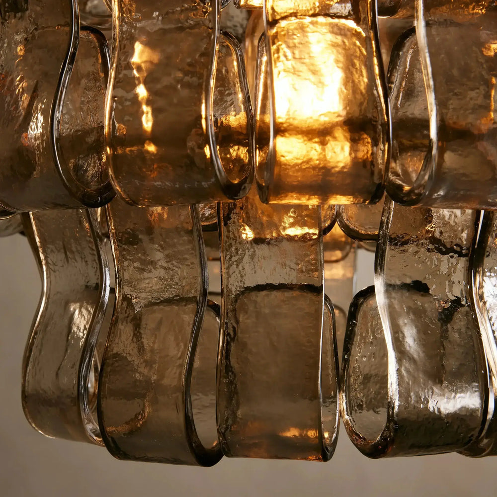 
                  
                    Close-up of a vintage-style chandelier with glass shades on a neutral background
                  
                
