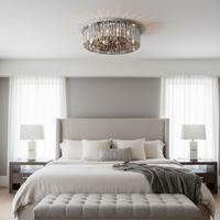 Modern bedroom with a large bed, ottoman, and decorative lighting.
