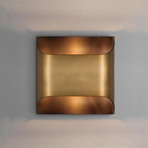 The Rame Modern Copper Wall Lights by Morsale offer a minimalist design, showcasing a square sconce with a curved, polished copper finish. Its warm, golden tone beautifully contrasts against a neutral gray background, making it perfect for enhancing your home decor lighting with elegance.