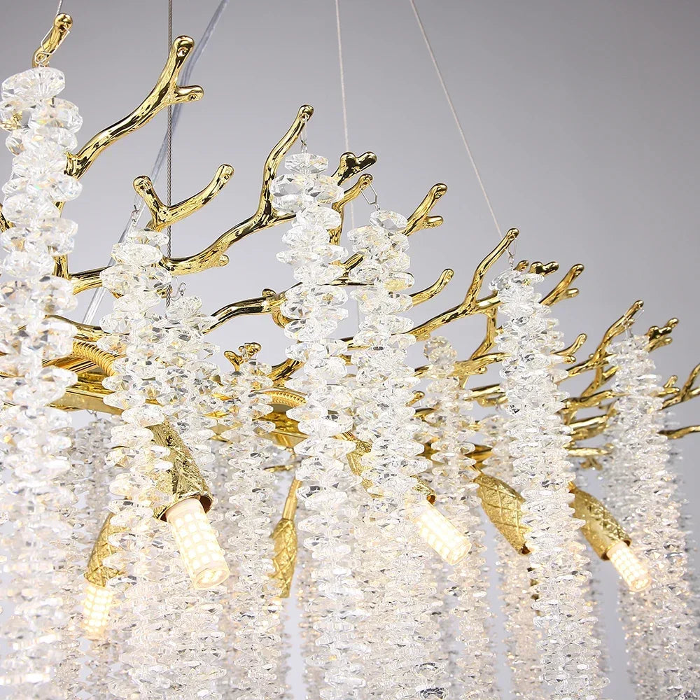 A modern, rectangular Albero Kitchen Ceiling Light Fixture from Morsale.com hangs above a dining table, featuring cascading crystal-like elements and multiple light bulbs. The room has a minimalist design with neutral tones, and a bowl of fruit can be seen on the table below the chandelier.