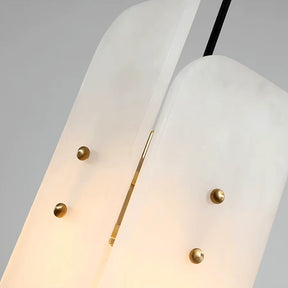 Here's a revised version of the sentence using the provided product data:

Close-up of a Morsale Moonshade Natural Marble Pendant Light showcasing its two elegantly curved, opaque white panels with rounded edges, joined by small brass studs. This design emits a warm glow between the panels, enhancing its luxurious and sleek appearance.