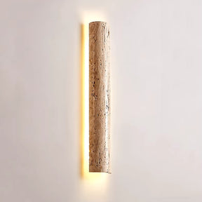 The IP65 Waterproof Natural Travertine Wall Light by Morsale is a wall-mounted cylindrical sconce featuring LED illumination. Crafted from textured stone, it emits a soft, warm light that emphasizes its natural surface. Its gentle glow enhances a plain white wall, adding to an elegant and modern design ambiance.