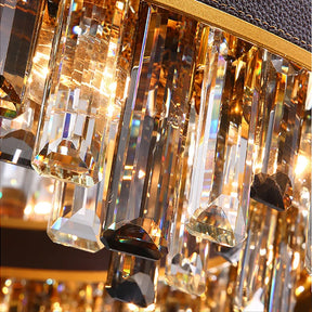 Close-up image of an elegant, modern chandelier featuring multiple crystal prisms reflecting light. The crystals are arranged in vertical rows, displaying a gold hue due to the lighting, creating a dazzling and luxurious effect. The Calvi Modern Chandelier by Morsale.com exemplifies luxury lighting while incorporating energy-efficient LED technology.