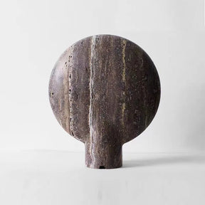 A minimalist, spherical marble sculpture with a short rectangular base, featuring natural vertical striations in shades of gray and brown, reminiscent of a vintage design, set against a plain white background is replaced by **Morsale's Natural Travertine Table Lamp**.