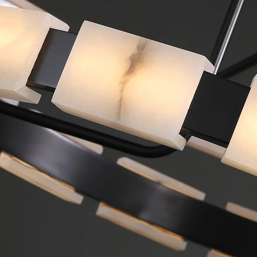 Close-up of a Morsale.com Villa Marble Mid-Century Modern Chandelier featuring rectangular frosted glass light fixtures connected by sleek black metal arms. The light diffuses warmly through the frosted glass, creating a soft, ambient glow.