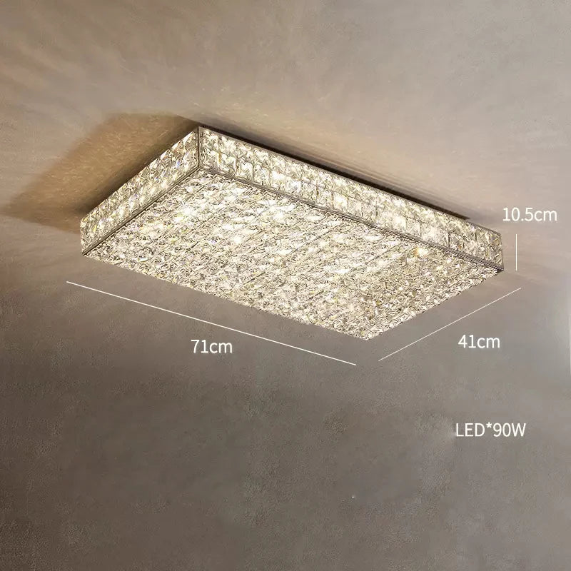 A rectangular **Bacci Clear Crystal Light Fixture** by **Morsale.com**, resembling a crystal ceiling chandelier, is mounted on a beige ceiling. Measuring 71 cm in length, 41 cm in width, and 10.5 cm in height, this modern lighting fixture uses 90W LED bulbs and features a textured, crystalline design for touch of luxury decor.