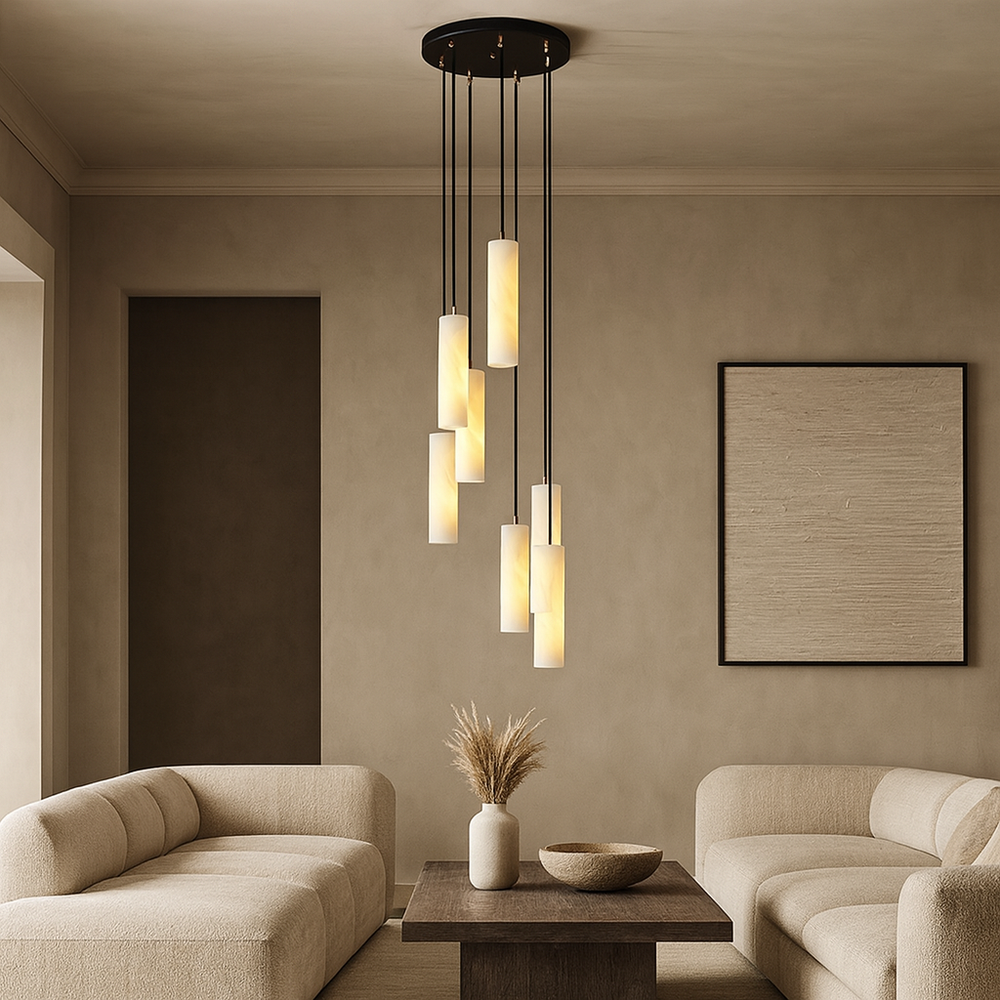 
                  
                    A modern living room features two beige sofas, a wooden coffee table with a vase of dried wheat, textured wall art, and Linea Natural Marble Pendants by Morsale.com with dimmable lighting hanging from the ceiling.
                  
                