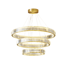 The Roma 3-Tier Modern Chandelier by Morsale.com showcases three circular, gold-toned rings of different sizes, each embellished with vertical glass crystals and equipped with integrated LED lighting. Suspended from a high-quality stainless steel ceiling mount by several thin cables, the rings descend in a tiered design, gradually decreasing in size.