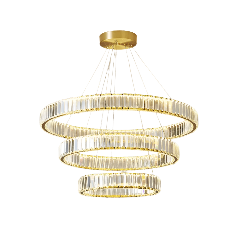 The Roma 3-Tier Modern Chandelier by Morsale.com showcases three circular, gold-toned rings of different sizes, each embellished with vertical glass crystals and equipped with integrated LED lighting. Suspended from a high-quality stainless steel ceiling mount by several thin cables, the rings descend in a tiered design, gradually decreasing in size.