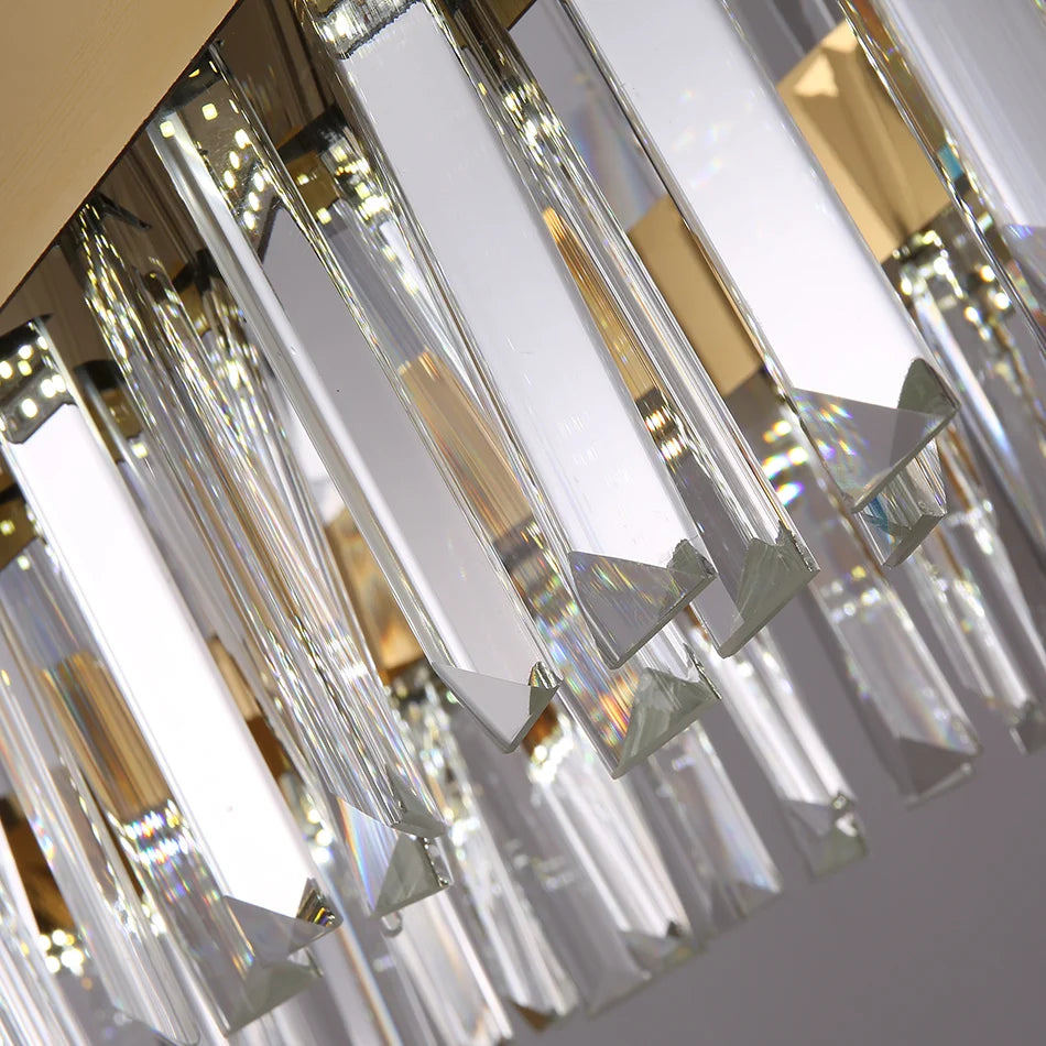 Close-up of the Calvi Crystal Dining Room Light Fixture by Morsale.com, featuring numerous elongated, handmade crystal prisms with pointed ends, mounted on a metallic gold base. The prisms reflect light, creating a sparkling, elegant effect perfect for dining room lighting.