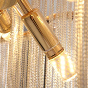 Close-up shot of the Cadena Chain Tassel Ceiling Light from Morsale.com, featuring a gold-colored, cylindrical LED flush mount design with multiple small lights. The fixture is enhanced by cascading Cadena chain tassel strands, creating a luxurious and sophisticated ambiance. Perfect for modern elegant lighting needs.