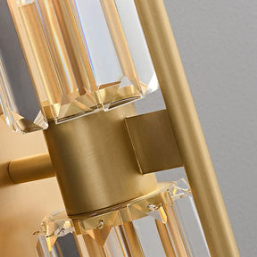 Here's a rewritten version of the sentence using the given product data:

A close-up of Morsale's Gio Double Head Crystal Wall Sconce showcases its gold finish and rectangular crystal accents, emanating LED brilliance. Light reflects through the crystals to create a prism effect, while a neutral-toned wall behind enhances the elegance and modern style of this sophisticated fixture.