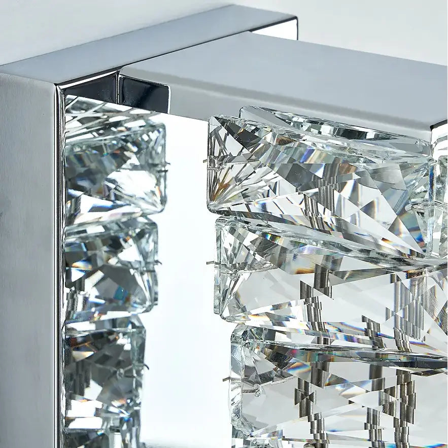 Close-up of the Bacci Crystal Wall Sconces by Morsale.com, showcasing multiple rectangular crystal prisms mounted on a shiny chrome frame. The crystals are arranged in a cascading design, reflecting light to create a sparkling effect that perfectly embodies modern design aesthetics.