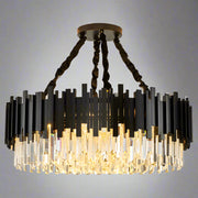 The Gio Modern Chandelier by Morsale features a contemporary circular design with staggered black and clear glass elements. It has a crystal shade suspended from a round ceiling mount with four twisted black cables, creating a warm glow.