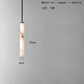 A slender, modern pendant light hangs from a black cord against a plain gray background. The Natural Marble & Brass Pendant Light Fixture from Morsale.com is 30cm tall and 6cm wide, featuring a polished copper finish with a 10W LED bulb. Text specifies the materials and dimensions.