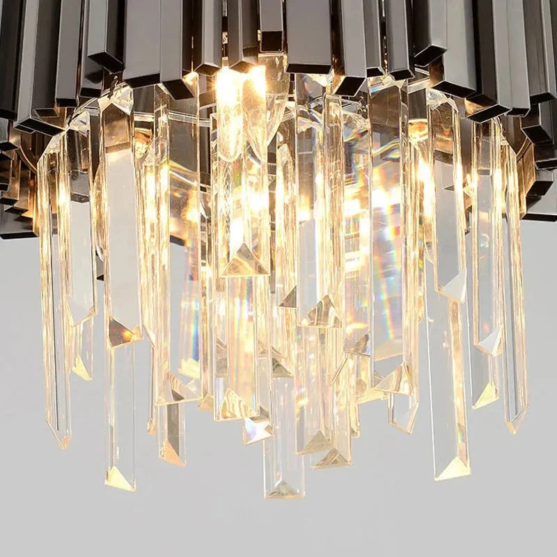 A close-up of the luxurious Gio Kitchen Island Light 12" by Morsale.com, showcasing its multiple dangling K9 crystal prisms. The warm light illuminates and reflects beautifully off the crystals. Text below the image reads "K9 crystal." The chandelier’s stainless steel frame adds a modern touch to its elegant design.