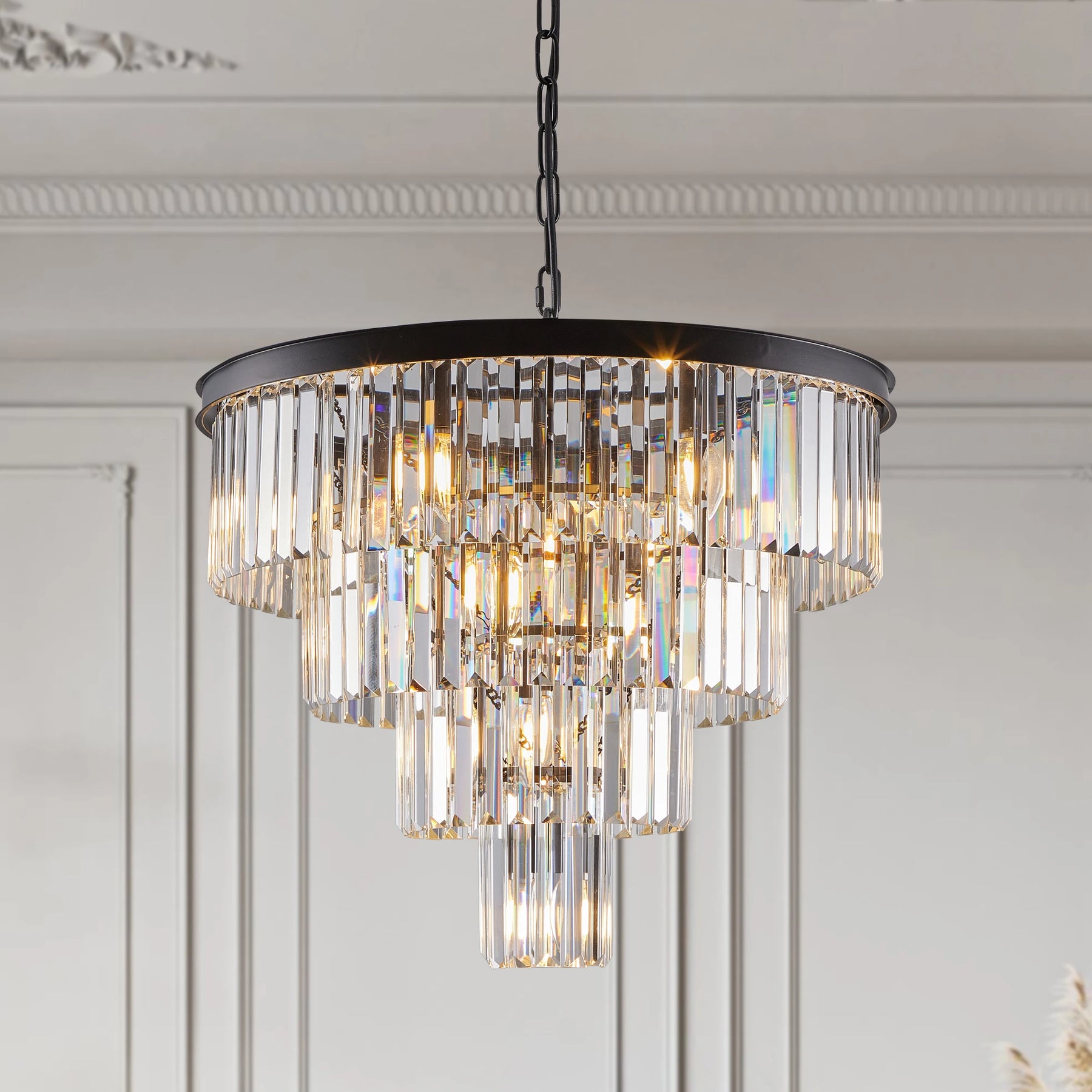 Morsale's 23.6" Gio Crystal Chandelier features a tiered design and sparkling glass prisms, casting a warm glow to create a luxurious atmosphere in any ornately molded room.