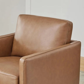Close-up of a Morsale Genuine Leather Swivel Lounge Chair featuring a modern design with clean lines and a cushioned backrest. Positioned against a neutral wall on a light floor, it adds warmth and coziness to the room. Simple assembly ensures easy enhancement of your space.