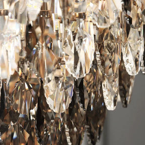 A close-up of a luxurious crystal chandelier with faceted teardrop-shaped pendants reflecting the light showcases the Lazzo Contemporary Chandelier from Morsale, which embodies elegance. Below, text appears in both Chinese and English, accompanied by a logo featuring the words "CRYSTAL ORIGIN & DELUXE.