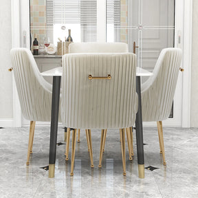 A modern dining room displays the Modern Glam Boucle Pleated Velvet Dining Chair Set of 4 by Morsale, featuring cream-colored seating with gold accents around a white table. It boasts marble flooring and soft-toned cabinets, epitomizing chic home furniture elegance.