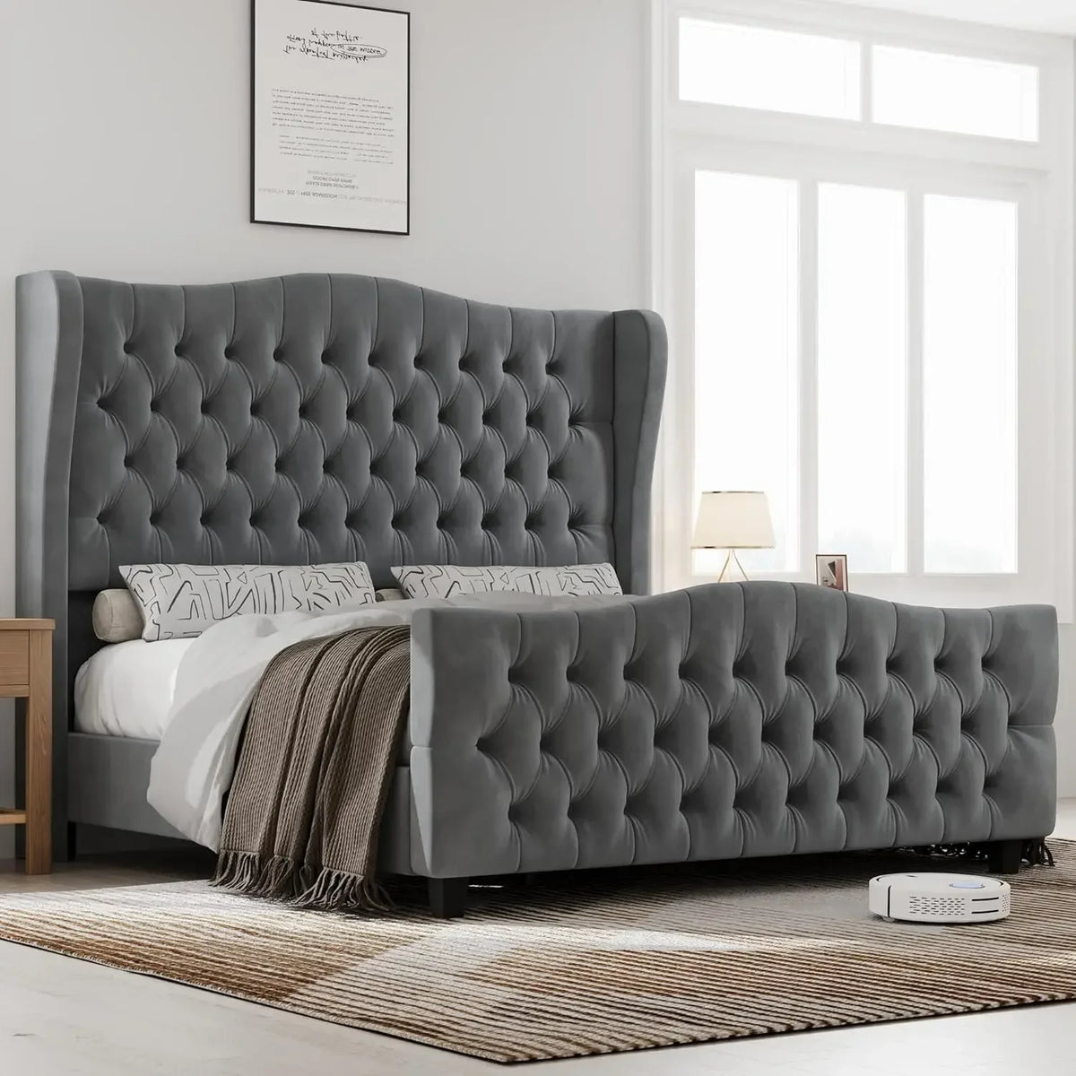 A luxurious bedroom features a large Morsale Velvet Button Tufted Bed with patterned pillows and a brown blanket. A bedside table with a lamp, sheer-curtained window, and cleaning robot on the floor complete the scene.