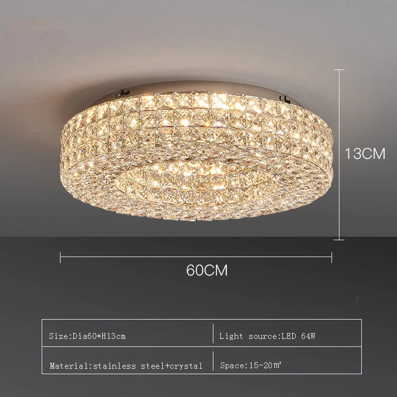 The Bacci Crystal Ceiling Light Fixture by Morsale, featuring LED bulbs, is elegantly installed on the ceiling, casting a warm glow. The illumination dances off the crystals, producing a sparkling effect. The room boasts modern decor with dark walls and offers a view of the dining area below.